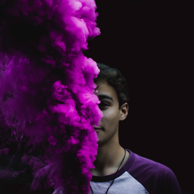 World IBD Day 2018 image of a young man with an explosion of purple powder in front of himself