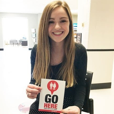 Emma Moore holding GoHere decal