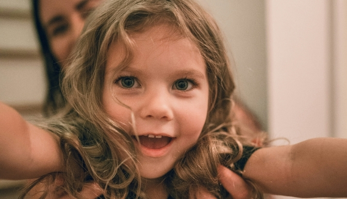 A young girl playing at being an airplane