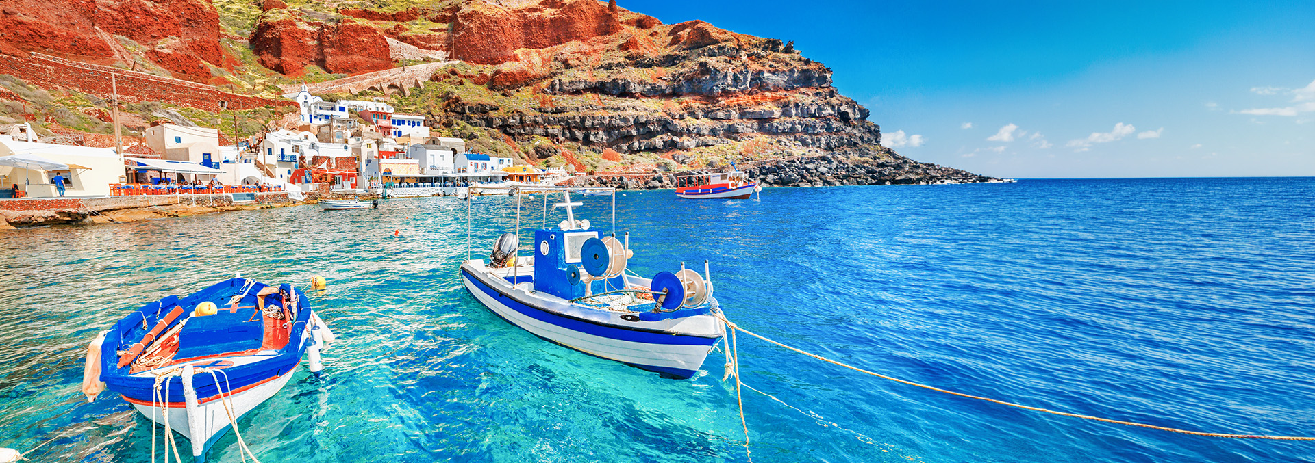 Boats off the coast of Greece in clear blue ocean