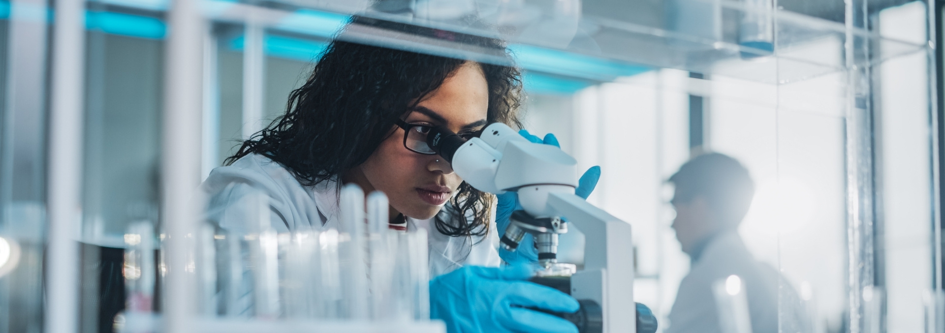 A researcher looking through a microscope