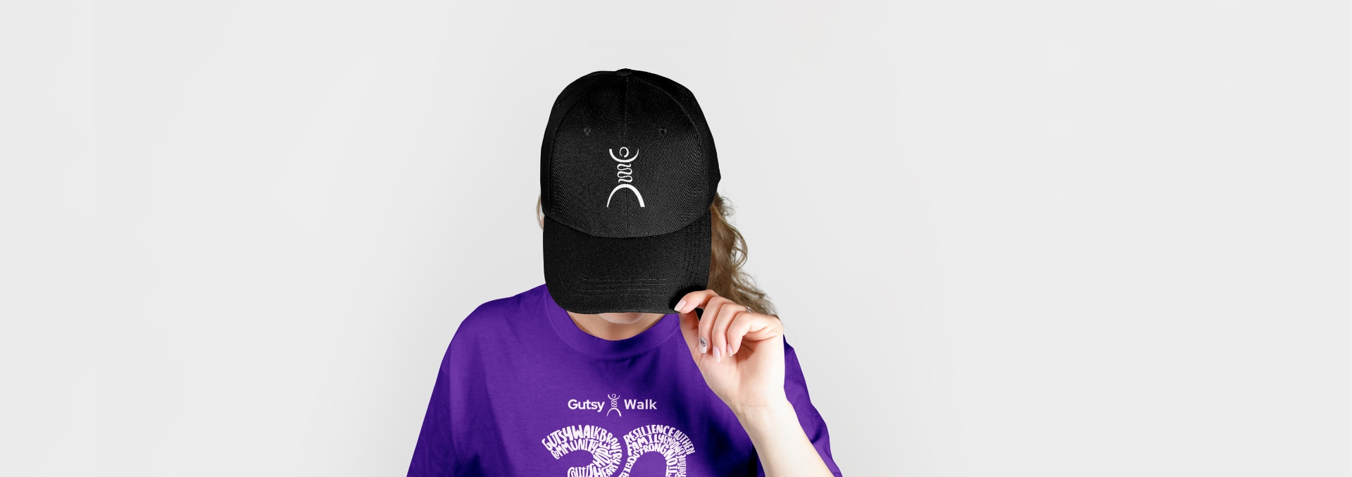 A young woman wearing a limited edition Gutsy Walk baseball-cap
