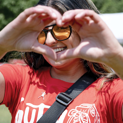 Participant at Gutsy Walk making a heart sign with her hands