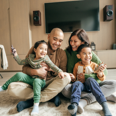 Family sitting on the floor of their living room playing