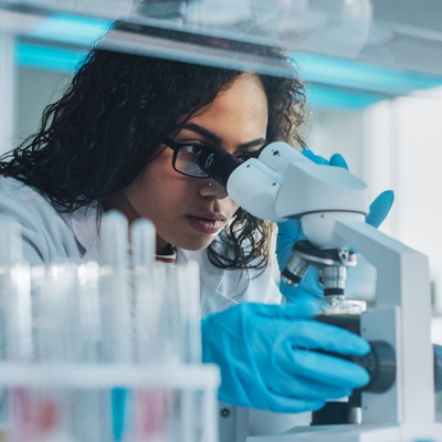 A researcher looking through a microscope