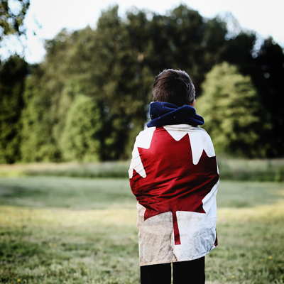 Young boy wrapped in Canadian flag