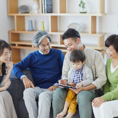 A family gathered around a child looking at a tablet